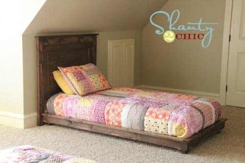 A low twin platform bed frame with a raised lip edge and tapered legs